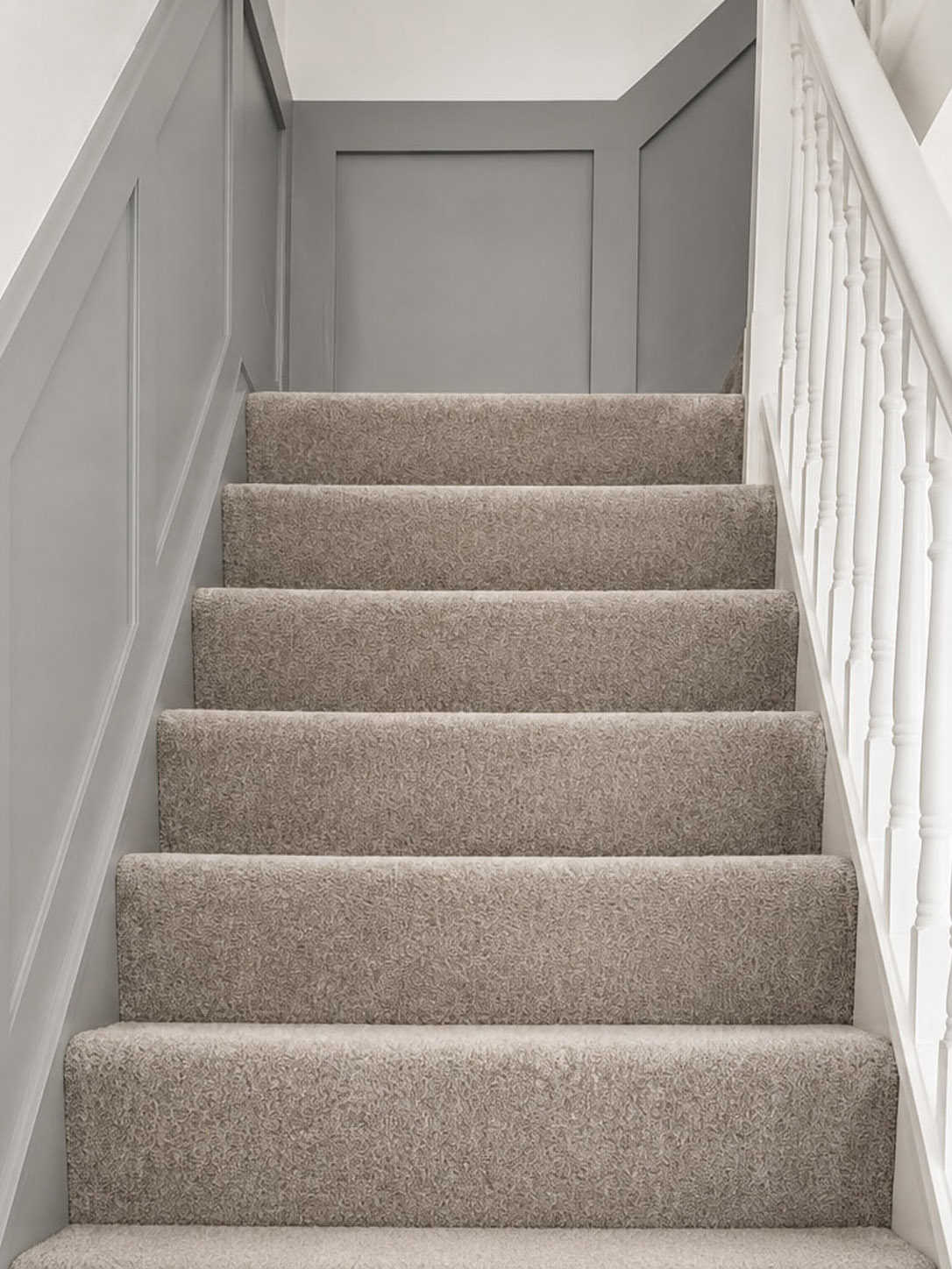 Angled grey wall panelling carefully fitted to follow the pitch of a staircase by Elite